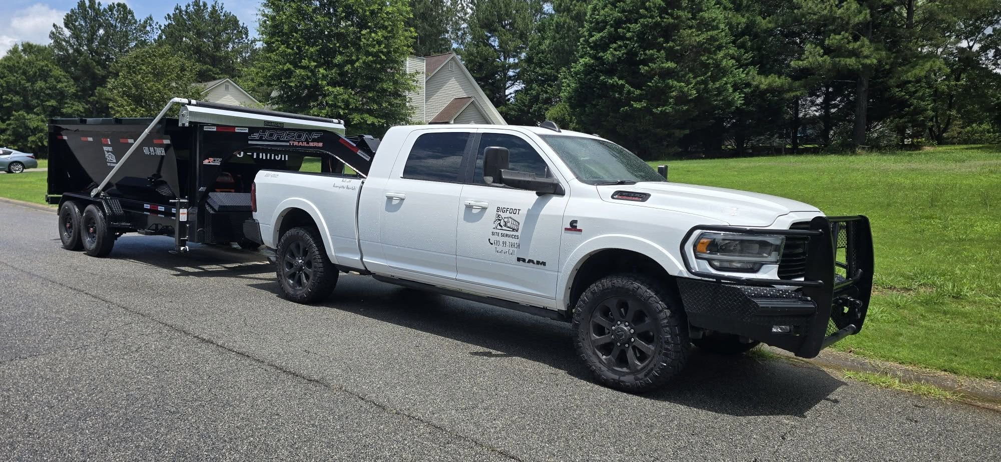 Bigfoot Site Services truck hauling a dump trailer through a Georgia neighborhood